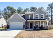 Charming two-story home featuring a welcoming front porch, attached garage, and beautiful architectural details at 9620 Corby Ct, Summerville, SC 29485