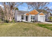 Charming home with a well-maintained lawn, mature tree, and partial wood facade at 1036 Oakcrest Dr, Charleston, SC 29412