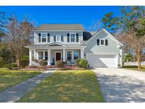Charming two-story home with blue siding, black shutters, covered porch, manicured lawn, and attached two-car garage at 107 Plank Ct, Summerville, SC 29485