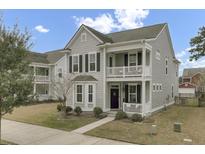 Charming two-story home with a double porch, gray siding, black shutters, and manicured landscaping at 1847 Grovehurst Drive, Charleston, SC 29414