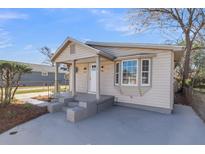 Charming home with a covered porch, neutral siding, and gray painted steps leading to the front door at 1987 Echo Ave, North Charleston, SC 29405