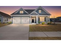 Charming home showcasing a two-car garage, landscaped yard, and craftsman-style architecture at sunset at 224 Fiddleback Dr, Summerville, SC 29486
