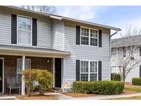 Charming townhome featuring vinyl siding, black shutters, and a cozy front entrance, creating an inviting curb appeal at 2494 Etiwan Ave # 12J, Charleston, SC 29414