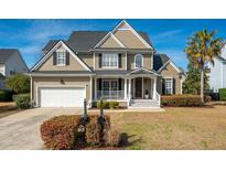 Charming two-story home with a well-manicured lawn, inviting porch, and attached two-car garage at 2972 Riverwood Dr, Mount Pleasant, SC 29466