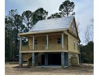 Charming raised home featuring a welcoming porch, elevated design, and classic architectural details at 3102 Hailey Ct, McClellanville, SC 29458