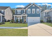 Charming two-story home featuring blue siding, white trim, a two-car garage, and a well-maintained front lawn at 429 Cherrybark Oak St, Summerville, SC 29486