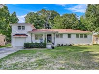 Charming brick home with a well-manicured lawn and inviting front porch and attached garage at 5332 Parkside Dr, North Charleston, SC 29405