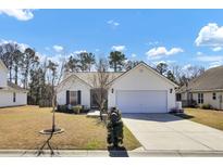 Charming single-story home with a well-manicured lawn, two-car garage, and traditional architectural details at 7426 Painted Bunting Way, Hanahan, SC 29410