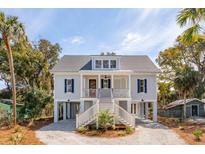 Charming elevated home featuring a welcoming double staircase and classic coastal design elements at 806 Jungle Rd, Edisto Island, SC 29438