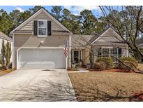 Charming home featuring a one car garage, American flag, neutral siding and well-maintained landscaping at 9021 Robins Nest Way, Summerville, SC 29485