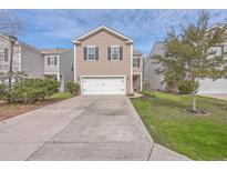 Charming two-story home with a two-car garage and long driveway surrounded by landscaping and a well-manicured lawn at 9790 Seed St, Ladson, SC 29456