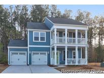Charming two-story home with a double front porch, attached two-car garage, and light blue siding at 1026 Marsh Harrier Dr # Cc3-1-10, Ravenel, SC 29470