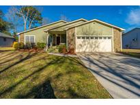 Charming single-story home featuring a two-car garage, stone accents, and beautiful landscaping at 1466 Arrow Wind Ter, Charleston, SC 29414
