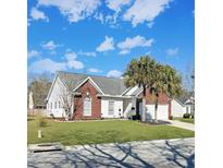 Charming home with brick accents, white siding, a well-manicured lawn, and beautiful mature palm trees at 1562 Sweet Myrtle Cir, Mount Pleasant, SC 29466