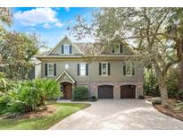 Charming home with a two-car garage, brick accents, and mature landscaping at 176 Marsh Hawk Ln, Kiawah Island, SC 29455