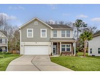 Charming two-story home with a well-manicured lawn and a two-car garage at 222 Medford Dr, Summerville, SC 29485