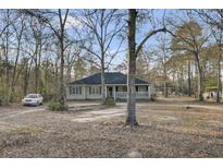 Charming single-story home with a welcoming front porch surrounded by mature trees and a spacious yard at 223 Fox Field Rd, Walterboro, SC 29488