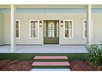 Charming front porch with green siding, lantern lights, and a welcoming entrance at 2725 Starfish Dr, Johns Island, SC 29455