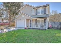 Charming two-story home with a well-maintained lawn, inviting front porch, and attached one-car garage at 2755 Lacy St, North Charleston, SC 29406