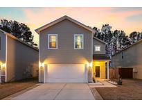 Charming two-story home with a two-car garage and well-lit exterior at dusk at 341 Iveson Rd, Summerville, SC 29486