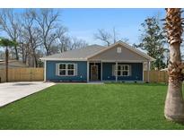 Charming blue home featuring a well-manicured lawn, grey roof and complimentary shutter accents at 39 Briarcliff Dr, Charleston, SC 29407