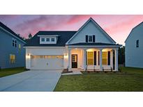 Charming single-Gathering home featuring white siding, a well-manicured lawn, and an attached two-car garage at 511 Verdi Dr, Summerville, SC 29486