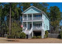 Charming two-story coastal home with double porches and a well-manicured front yard nestled amongst mature trees at 520 Sanders Farm Ln, Wando, SC 29492