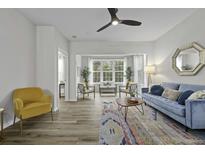 Bright living room with large window, stylish furniture, and modern ceiling fan at 60 Fenwick Hall Allee # 728, Johns Island, SC 29455