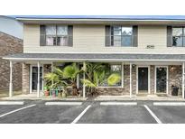 Inviting townhome with covered entry, parking, and decorative palms at 6244 Lucille Dr # B, North Charleston, SC 29406