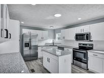 Modern kitchen featuring white cabinets, stainless steel appliances, and gray countertops at 7461 Church Hill Rd, Hollywood, SC 29449
