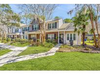 Charming two-story townhome featuring a well-manicured lawn and inviting front porch at 8120 Shadow Oak Dr, North Charleston, SC 29406