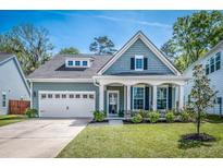 Inviting two-story home with landscaped front yard, white pillars, and black shutters at 9981 Winged Elm St, Ladson, SC 29456
