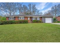 Charming single-story home with brick and gray siding, complemented by a well-manicured lawn and a white garage door at 1004 Wheeler Dr, Hanahan, SC 29410