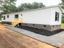 Charming single-story home featuring white siding, black shutters, and a newly landscaped front yard at 111 Sandy Oaks Ln, Cross, SC 29436