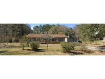 Charming single-story home with a brown roof and a well-maintained lawn and landscape at 1557 Old Whitesville Rd, Moncks Corner, SC 29461