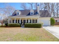 Charming one-story home with covered porch, dormers, manicured bushes, and attached garage at 1656 Lauda Dr, Mount Pleasant, SC 29464