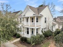 Charming two-story home with double porches and manicured landscaping creating a welcoming curb appeal at 1878 Carolina Bay Dr, Charleston, SC 29414