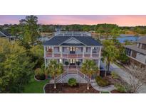 Stunning two-story home with dual staircases, double porches, manicured lawn, palm trees, and spectacular views at 2040 Ashburton Way, Mount Pleasant, SC 29466