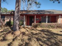 Charming single story home featuring a brick facade, covered porch, and mature landscaping at 205 Longstreet St, Summerville, SC 29486