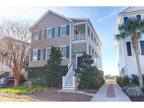 Charming two-story home with a spacious front porch and landscaped front yard at 23 Lowndes Pointe Dr, Charleston, SC 29403
