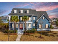 Charming blue two-story home with a welcoming front porch and meticulously maintained landscaping at 2975 Yachtsman Dr, Mount Pleasant, SC 29466