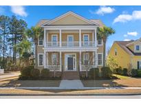 Charming two-story home featuring a double porch, landscaped yard, and palm trees at 301 Forsythia Ave, Summerville, SC 29483