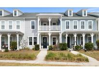 Charming townhouse with double porch, white railings, and beautiful landscaping at 3125 Sturbridge Rd, Mount Pleasant, SC 29466