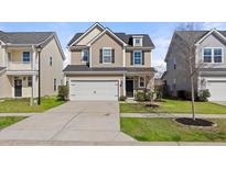 Two-story home with a two-car garage, dark shutters, and landscaping in the front yard at 324 Saucer Rd, Summerville, SC 29486