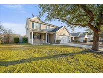 Charming two-story home with a welcoming front porch and well-maintained lawn at 521 Holiday Dr, Summerville, SC 29483