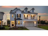 Charming two-story home with a second-story balcony and a well-manicured lawn at 587 Red Monarch Way, Moncks Corner, SC 29461
