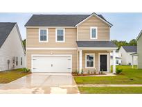Two-story home with tan siding, a white garage door, and a well-manicured lawn at 607 Red Monarch Way, Moncks Corner, SC 29461