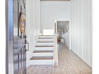 Bright entryway features wood-look floors and white wainscoting leading to the staircase at 743 Redbud Ln, Summerville, SC 29486