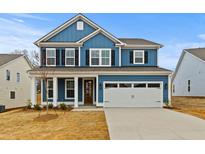 Charming two-story home featuring blue siding, black shutters, and a spacious two-car garage at 750 Opal Wing St, Moncks Corner, SC 29461