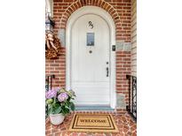 Charming brick archway frames the white front door with a welcome mat and lovely hydrangea accent at 95 Plymouth Ave, Charleston, SC 29412
